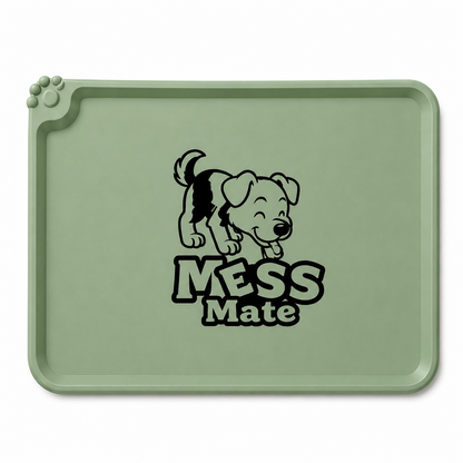 A sage green silicone dog training mat with a black cartoon puppy graphic and the text 'MESS MATE' printed in the center, shown on a plain white background.