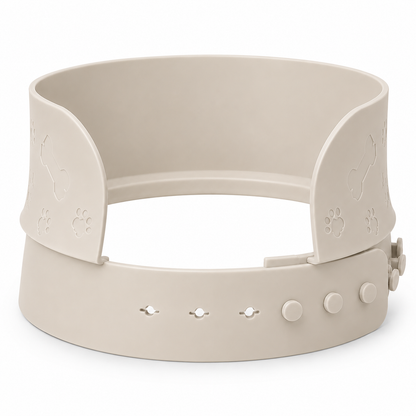 A beige adjustable splash guard to attach to bowls by MessMate with embossed paw print designs on the side flaps and a quick-release buckle system on the front, shown on a plain white background.